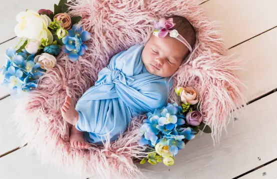 Slapende baby omringt met bloemen