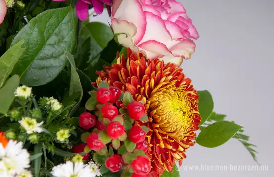 Bloemen op een vaas met takken groen erdoor